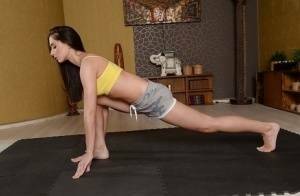 Cute brunette babe Aruna Aghora doing yoga in shorts and bare feet on picsfans.net